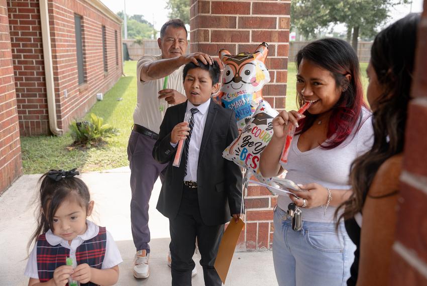 The Avila family hangs outside after Jeremas’ 5th grade graduation ceremony, Tuesday, May 20, 2025, in Houston. (Lexi Parra for The Texas Tribune)